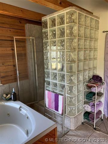 full bath with a stall shower, tile patterned flooring, wood walls, and a whirlpool tub