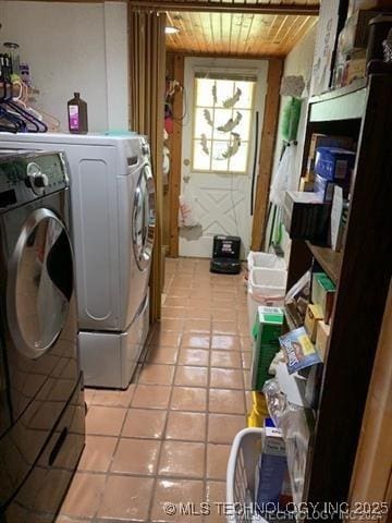 clothes washing area featuring laundry area, wood ceiling, light tile patterned floors, and washing machine and clothes dryer