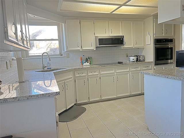 kitchen featuring stainless steel appliances, light stone counters, and a sink