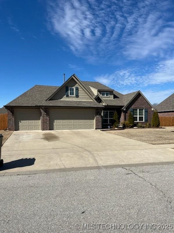 view of front facade with brick siding, fence, driveway, and an attached garage