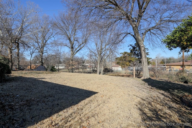 view of yard featuring an outbuilding, a storage unit, and fence