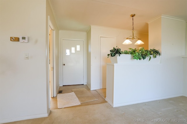 entrance foyer featuring baseboards, ornamental molding, and light colored carpet