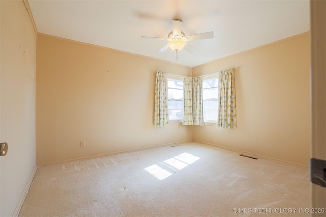spare room with carpet floors, ornamental molding, baseboards, and ceiling fan