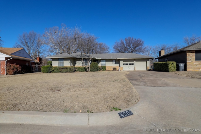 single story home featuring a garage, brick siding, and concrete driveway
