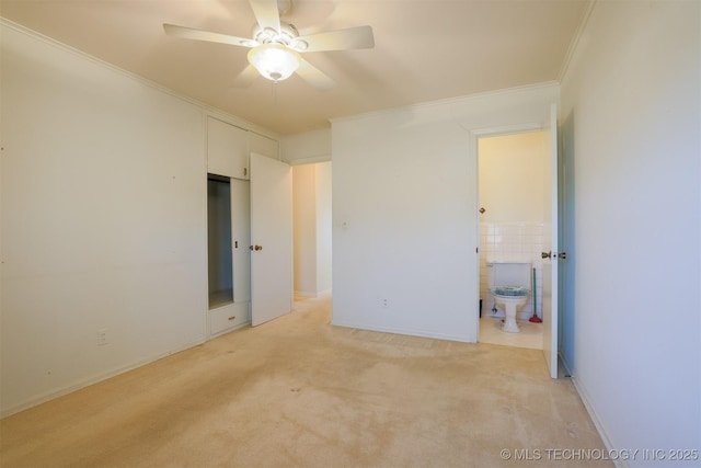 unfurnished bedroom featuring connected bathroom, light colored carpet, crown molding, and tile walls