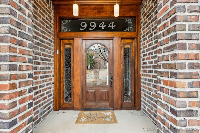 view of exterior entry featuring brick siding