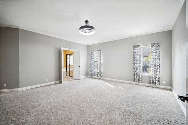 empty room with carpet, baseboards, and crown molding