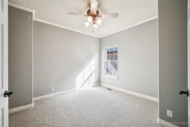 carpeted spare room with baseboards, visible vents, ceiling fan, and crown molding