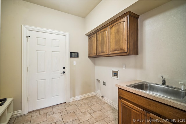 clothes washing area with washer hookup, a sink, baseboards, cabinet space, and stone finish flooring