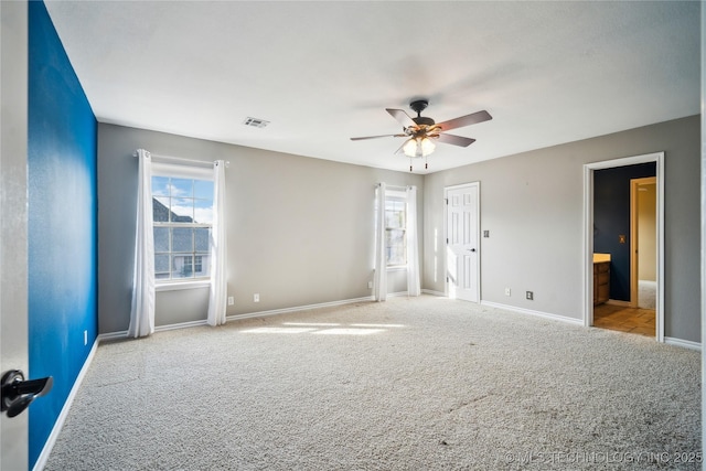 unfurnished room with light carpet, ceiling fan, visible vents, and baseboards