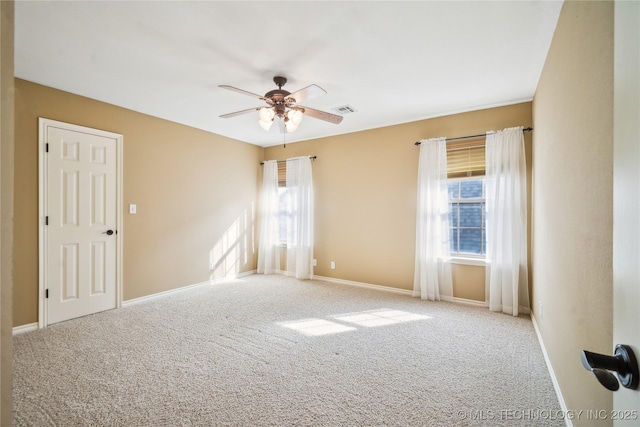 empty room with a ceiling fan, visible vents, light carpet, and baseboards