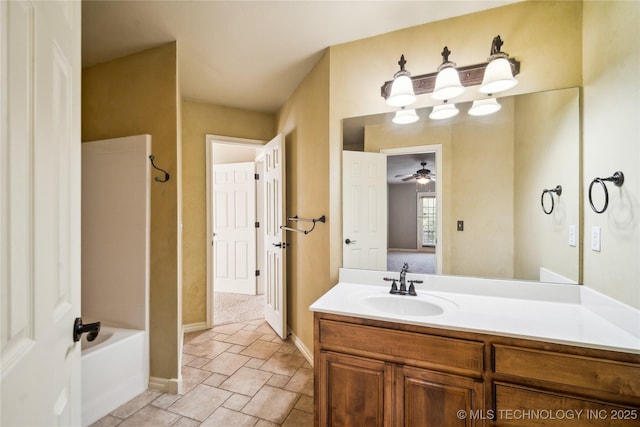 bathroom featuring stone finish floor, baseboards, a ceiling fan, and vanity