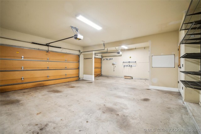 garage with baseboards and a garage door opener