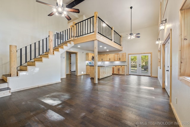 unfurnished living room featuring ceiling fan, baseboards, french doors, stairway, and dark wood-style floors