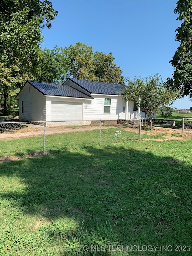 view of front of house featuring a front yard, metal roof, fence, and driveway