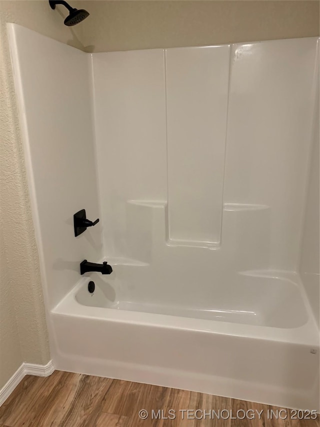 full bathroom featuring wood finished floors and bathing tub / shower combination