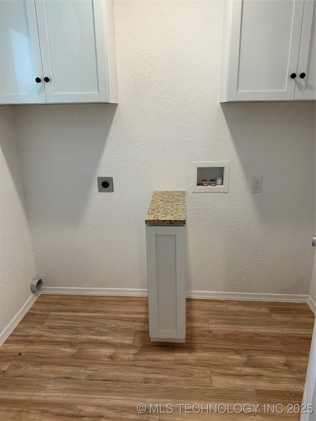 laundry room with hookup for a washing machine, cabinet space, light wood-style flooring, and baseboards