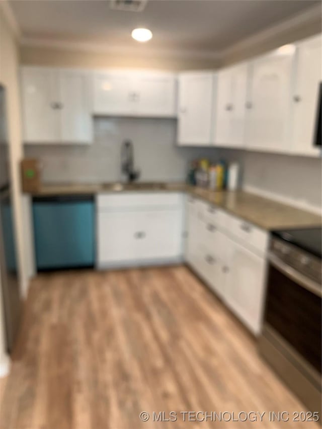 kitchen featuring white cabinets, range, light wood-style flooring, and a sink