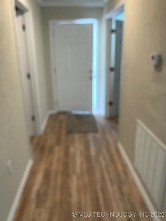 corridor with wood finished floors and baseboards