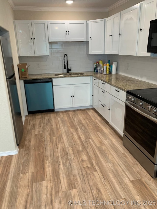 kitchen featuring stainless steel appliances, light wood-type flooring, a sink, and white cabinetry