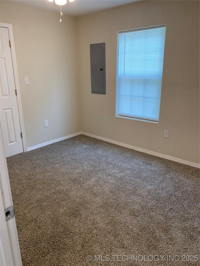 carpeted spare room with electric panel and baseboards