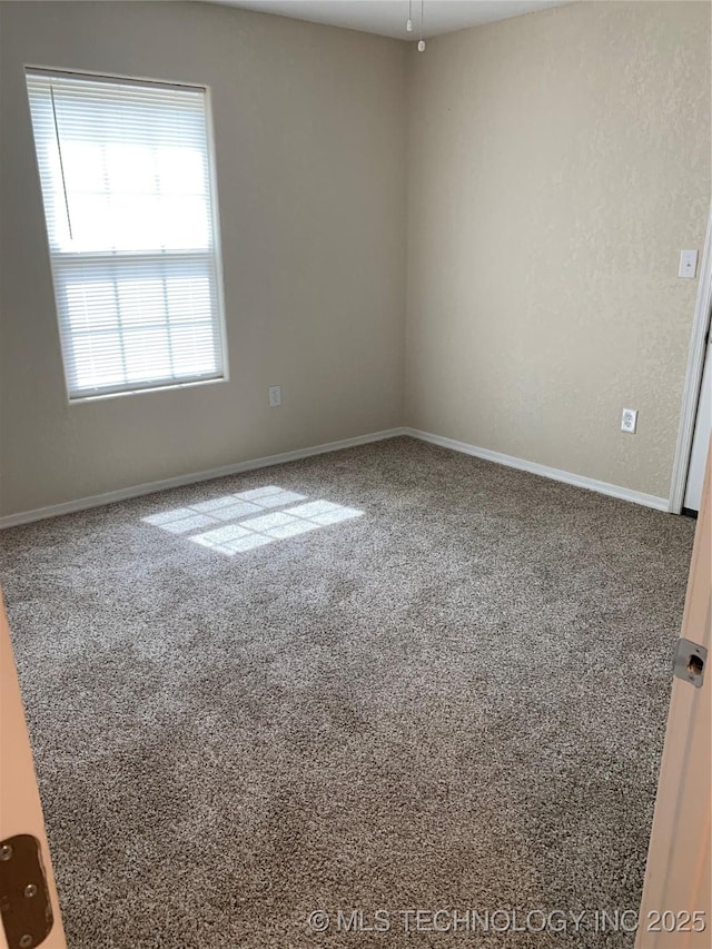 unfurnished room with carpet floors and baseboards