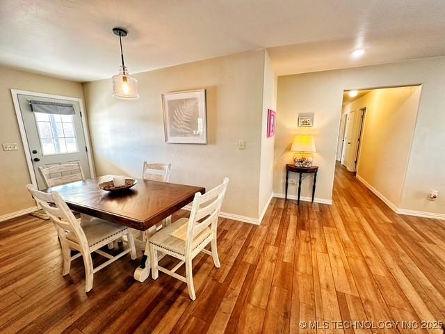 dining area with baseboards and wood finished floors