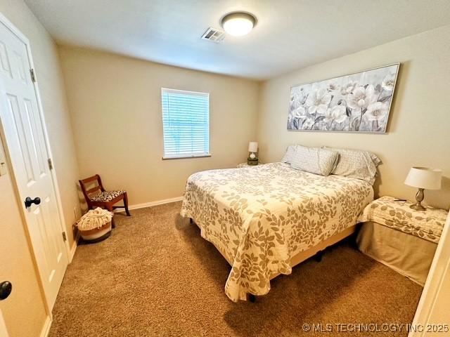 carpeted bedroom with visible vents and baseboards