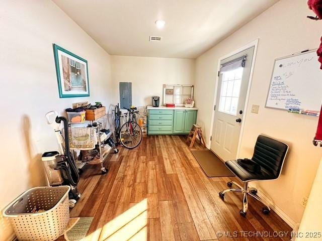 interior space with baseboards, visible vents, and light wood finished floors