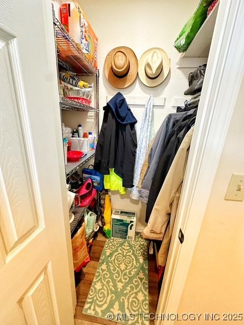 walk in closet with wood finished floors