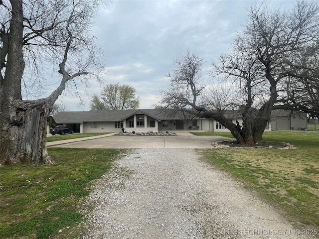 view of front of home featuring a front yard and gravel driveway