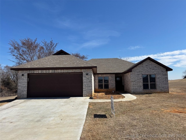 view of front of home featuring an attached garage, driveway, roof with shingles, and brick siding