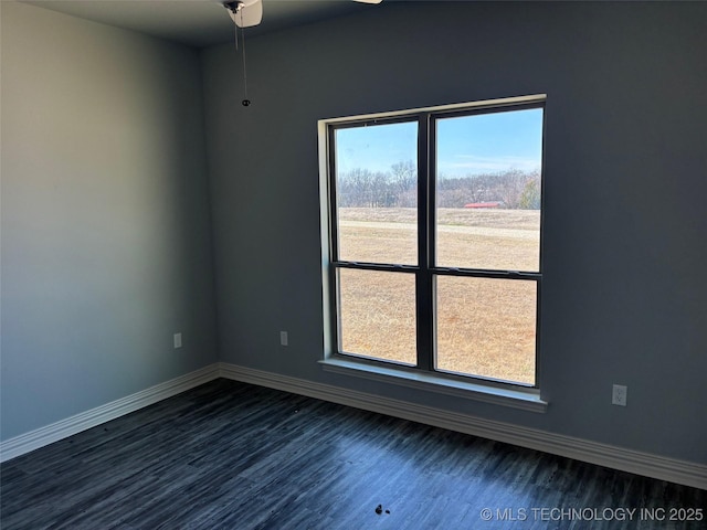 empty room with baseboards and dark wood-type flooring