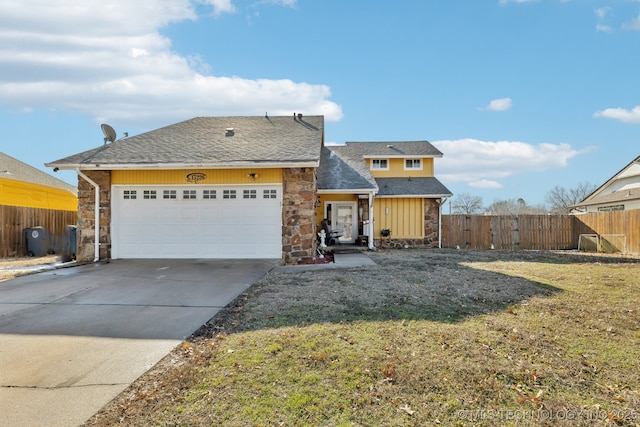 view of front of house with a garage, concrete driveway, stone siding, fence, and a front lawn