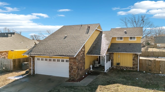 view of front of home featuring a garage, a shingled roof, fence, stone siding, and driveway