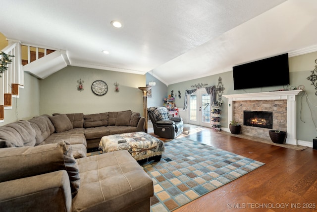 living room with lofted ceiling, stairway, dark wood-style flooring, french doors, and a fireplace