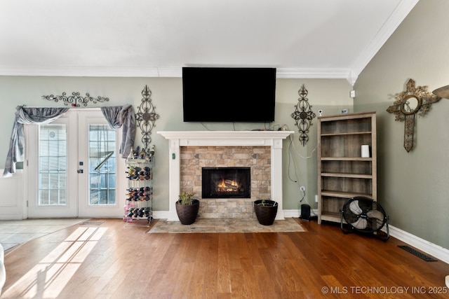 unfurnished living room featuring ornamental molding, french doors, baseboards, and wood finished floors