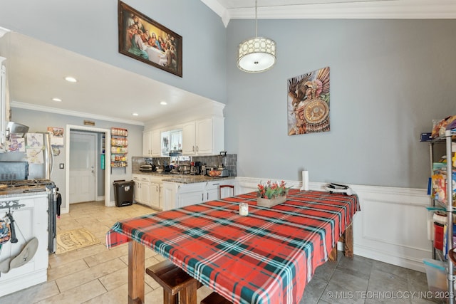 dining room featuring a wainscoted wall, recessed lighting, and crown molding