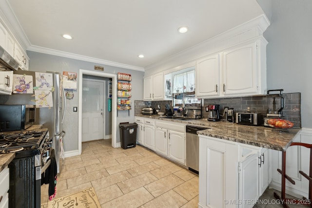 kitchen with crown molding, tasteful backsplash, appliances with stainless steel finishes, white cabinetry, and dark stone countertops