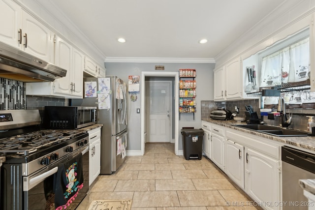 kitchen with white cabinets, appliances with stainless steel finishes, ornamental molding, under cabinet range hood, and a sink