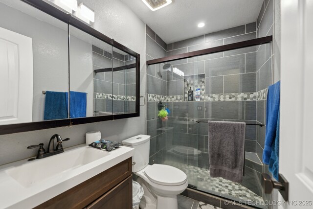 bathroom with toilet, a stall shower, visible vents, and vanity