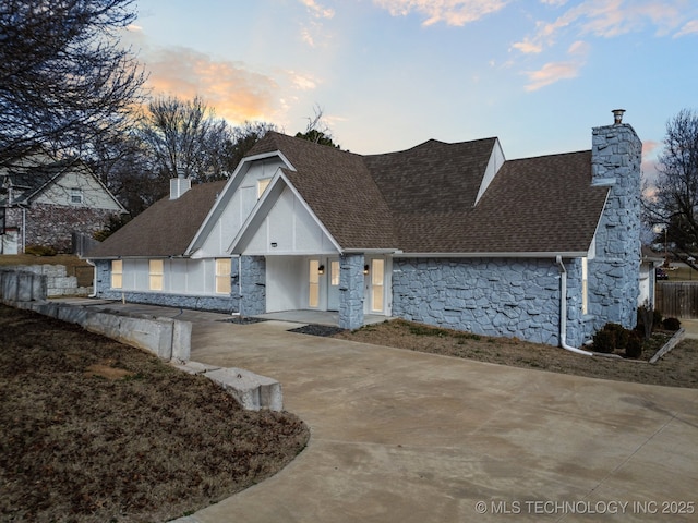 13433 S 125th E Ave, Broken Arrow, OK 74011 - view of front of home with stone siding, a chimney, concrete driveway, and roof with shingles