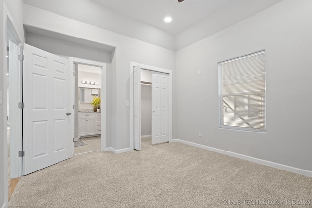 unfurnished bedroom featuring recessed lighting, ensuite bath, baseboards, and light colored carpet