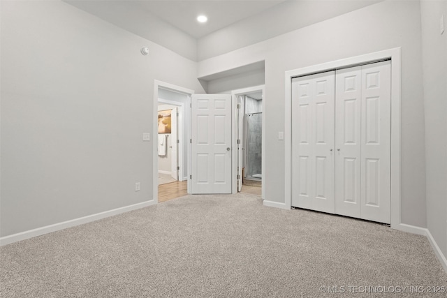 unfurnished bedroom featuring recessed lighting, a closet, light carpet, and baseboards