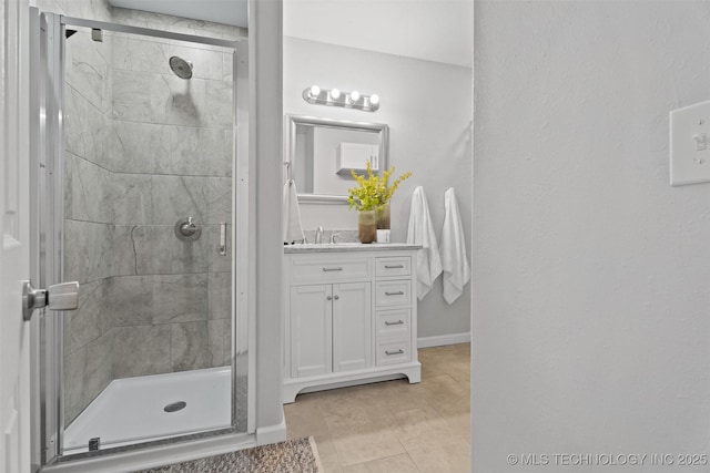 bathroom featuring a stall shower, baseboards, and vanity