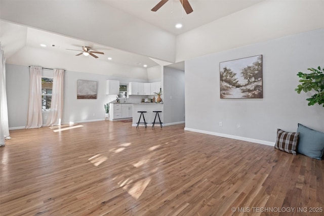 unfurnished living room featuring light wood finished floors, recessed lighting, and baseboards