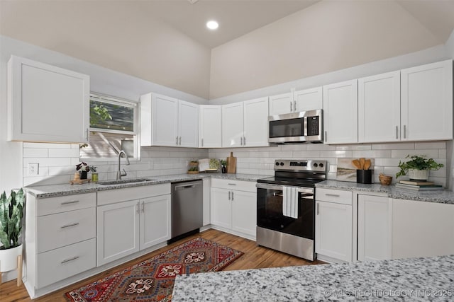 kitchen with white cabinetry, stainless steel appliances, and a sink