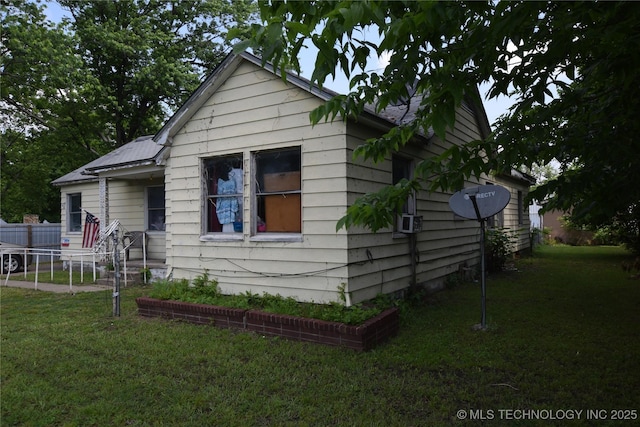 bungalow-style house with fence, cooling unit, and a front yard