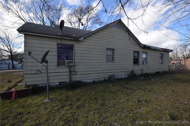 rear view of house with crawl space, a lawn, and roof with shingles