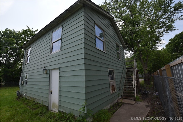 view of property exterior featuring stairs and fence